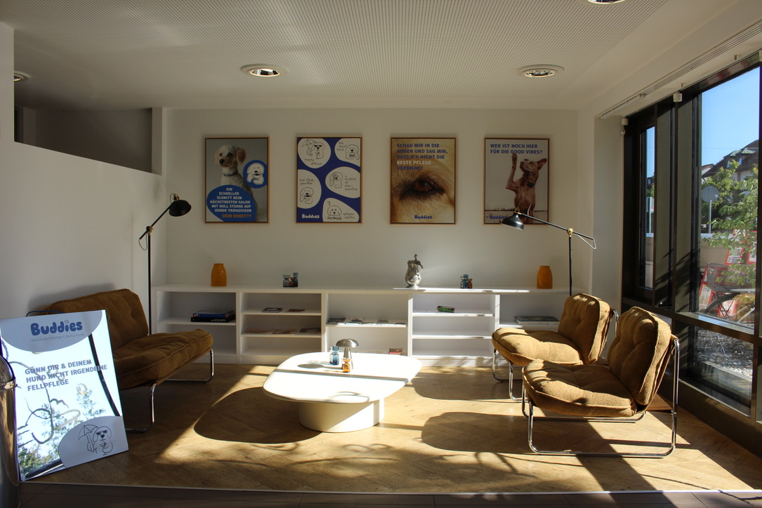 Heller Wartebereich mit Loungesesseln und Buddies Postern